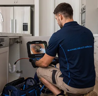 Plumber clearing a blocked toilet in a Lilyfield bathroom